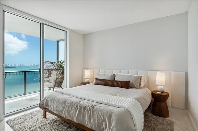 a bedroom with a large bed and a large mirror