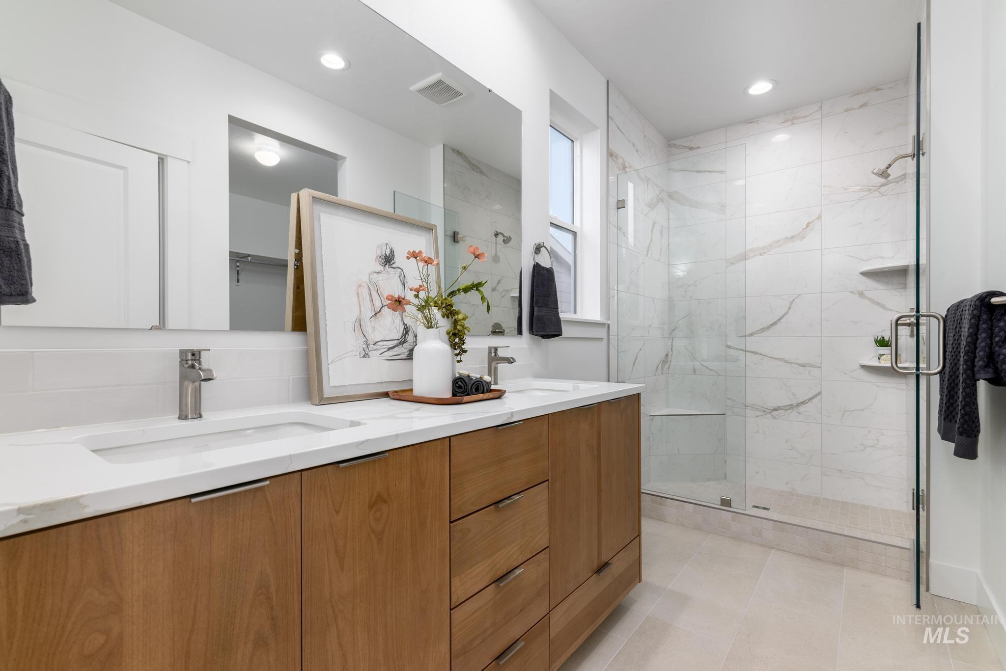 6167 West Snow Currant Street Meridian, ID 83646 - Photo 10 of 12 Dual vanity with integrated sinks, wood-finish cabinetry, and brushed nickel hardware