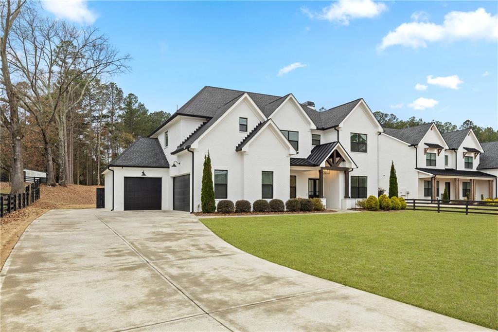 2381 Jones Phillips Road Dacula, GA 30019 - Photo 3 of 57 a front view of a house with a garden and yard