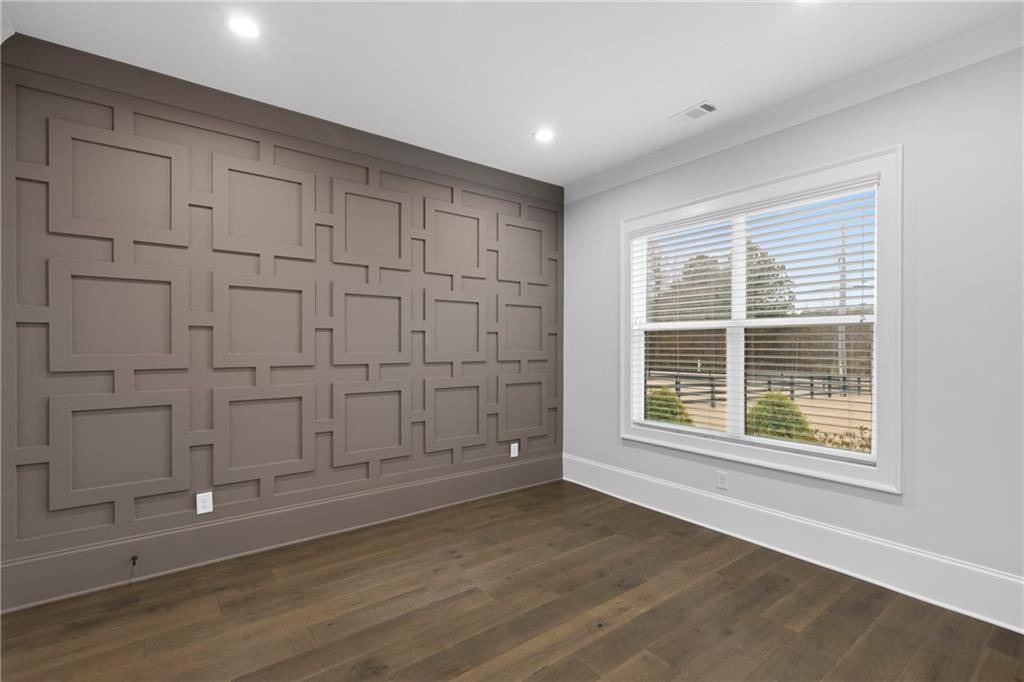 2381 Jones Phillips Road Dacula, GA 30019 - Photo 6 of 57 an empty room with wooden floor and cabinet