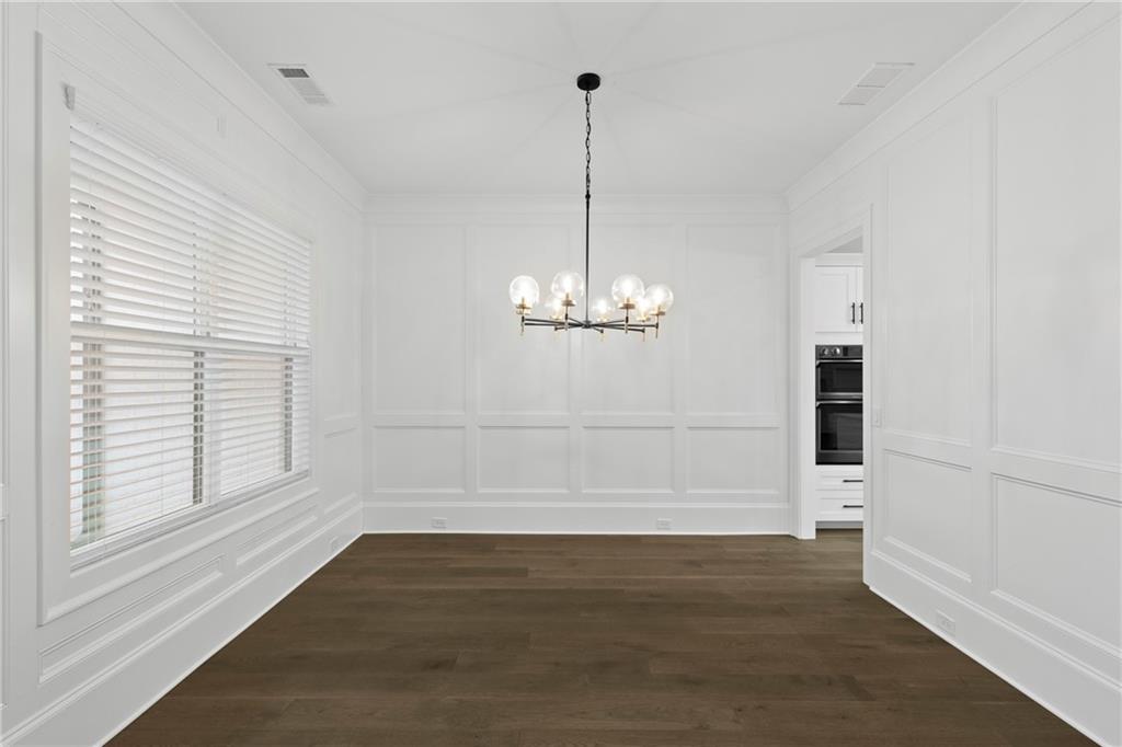 2381 Jones Phillips Road Dacula, GA 30019 - Photo 9 of 57 an empty room with wooden floor and windows