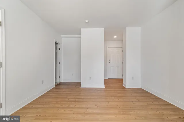 a view of an empty room with wooden floor