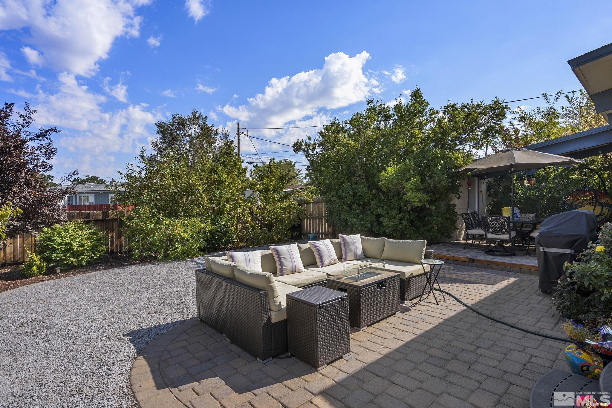 13693 Mt Baldy Street Reno, NV 89506 - Photo 18 of 18 a view of a patio with couches and chairs under an umbrella with a fire pit