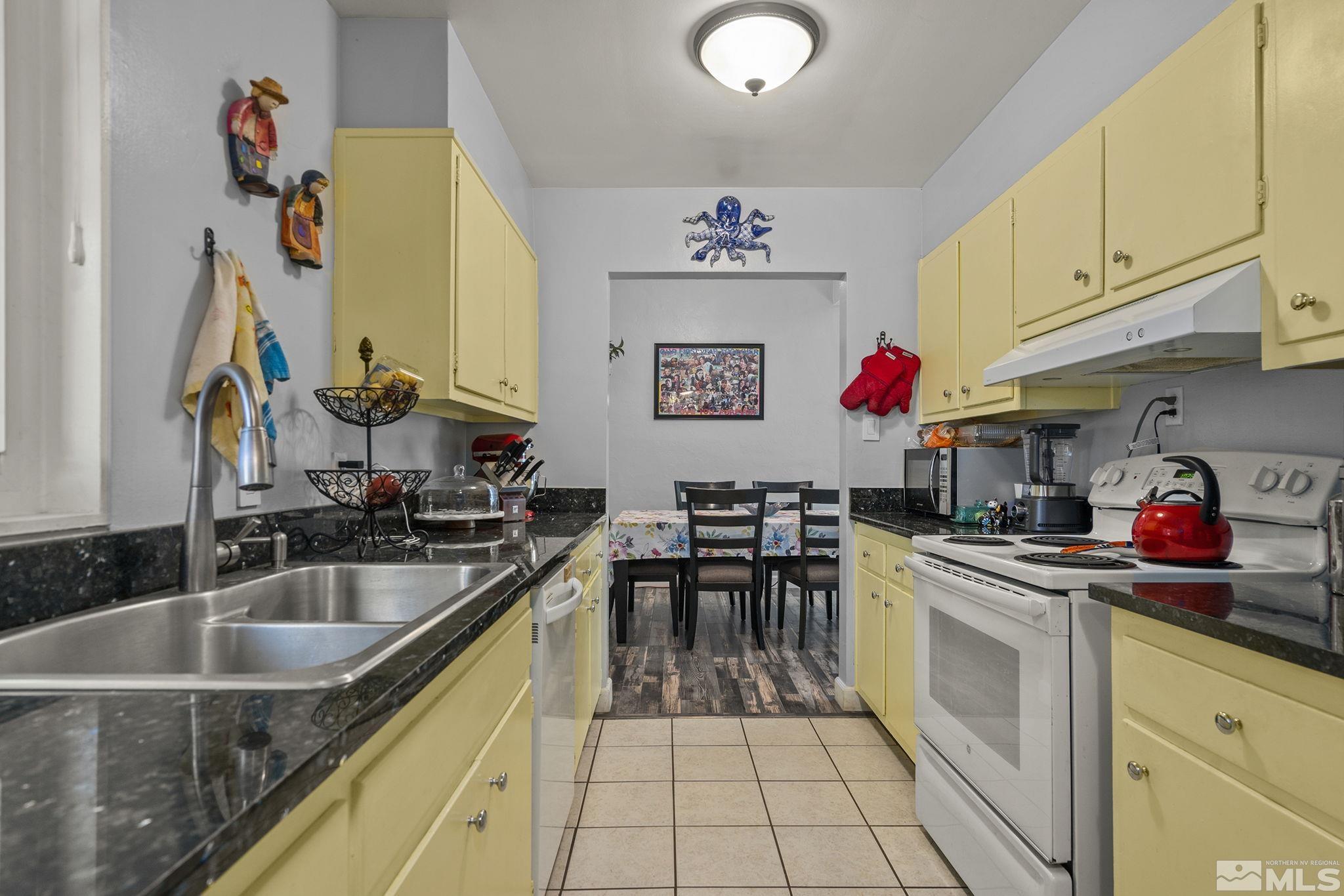 13693 Mt Baldy Street Reno, NV 89506 - Photo 9 of 18 a kitchen filled counter top space a sink a stove and white cabinets