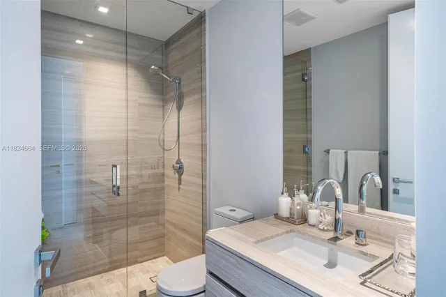 a bathroom with a sink shower and a mirror