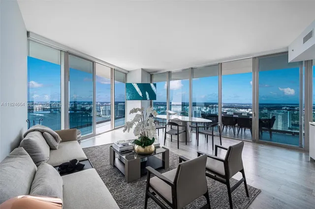 a living room with furniture kitchen view and large windows