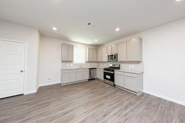 a kitchen with stove cabinets and wooden floor