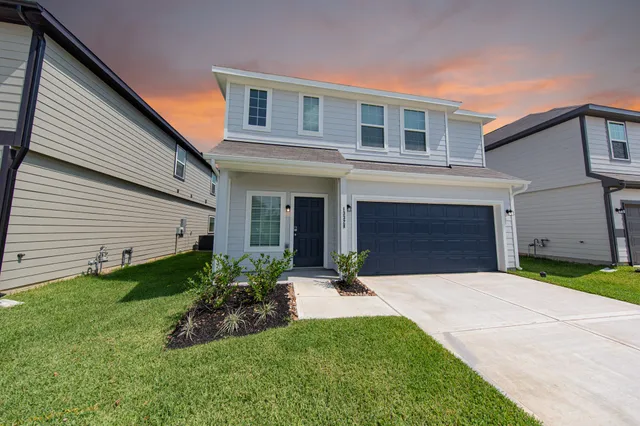 a front view of a house with a yard and garage