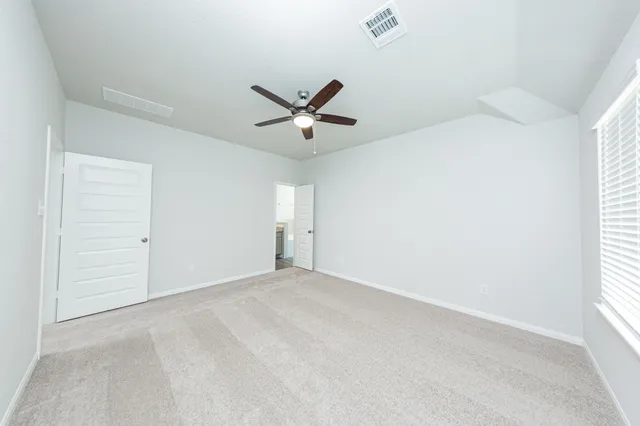 an empty room with closet and a ceiling fan