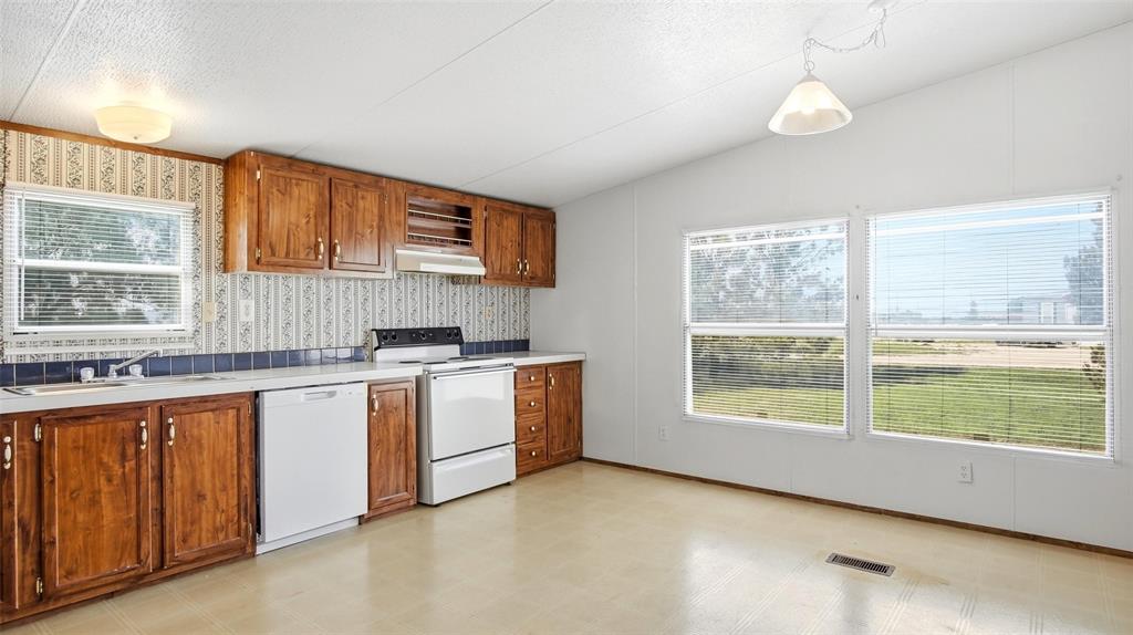 10902 County Road 414 Merkel, TX 79536 - Photo 12 of 26 a kitchen with a sink wooden cabinets and a window