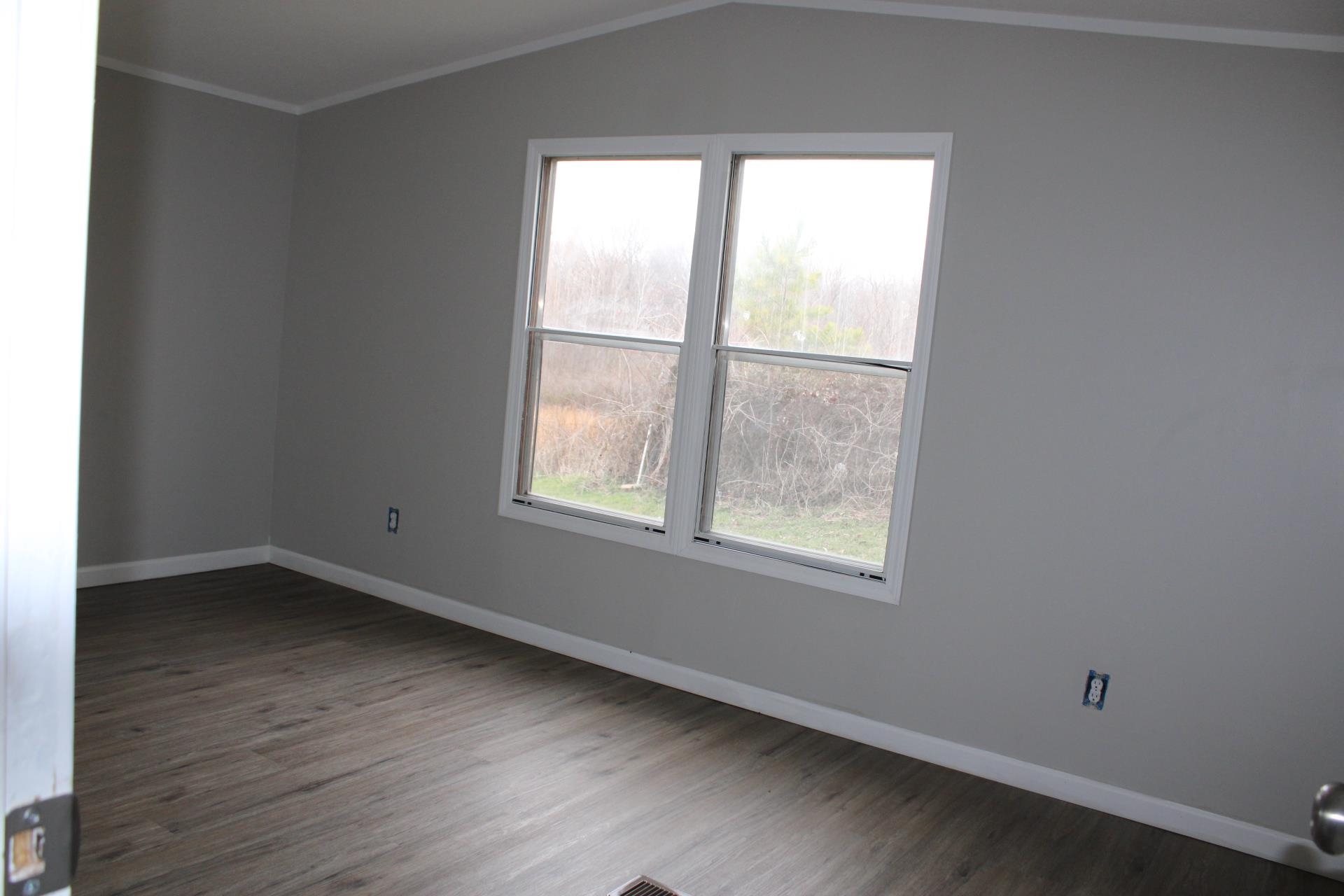1535 Sand Ford Road Henning, TN 38041 - Photo 21 of 40 an empty room with wooden floor and windows