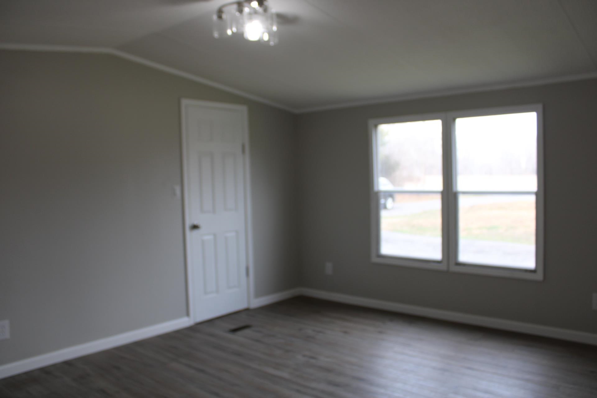 1535 Sand Ford Road Henning, TN 38041 - Photo 39 of 40 an empty room with wooden floor and windows
