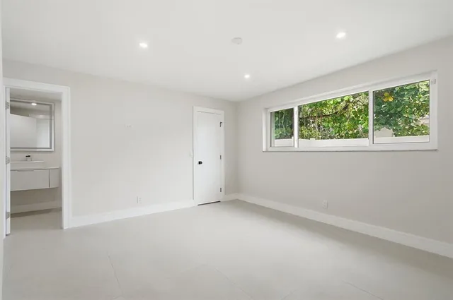 an empty room with windows and closet