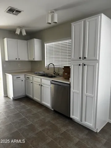 a kitchen with stainless steel appliances cabinets a sink and a refrigerator