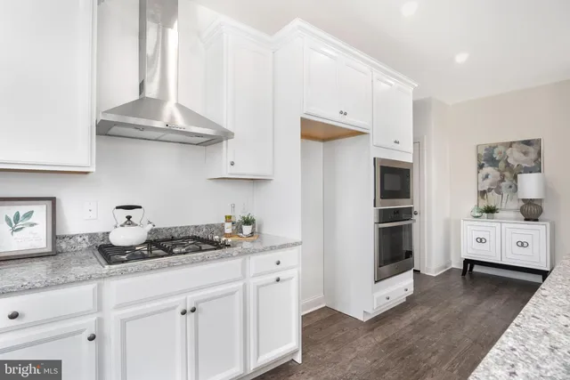 a kitchen with stainless steel appliances a white stove top oven and cabinets