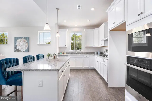 a large kitchen with granite countertop a sink a counter space appliances and cabinets