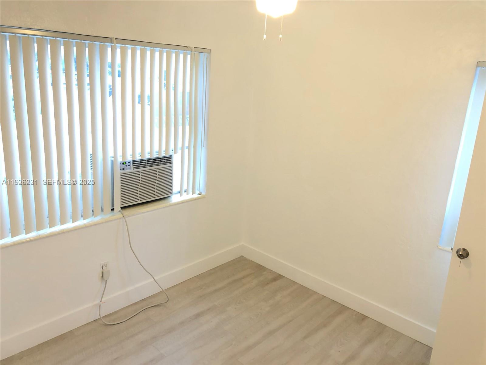 8340 Crespi Boulevard, Unit 19 Miami Beach, FL 33141 - Photo 15 of 35 a view of a small space with wooden floor and a window