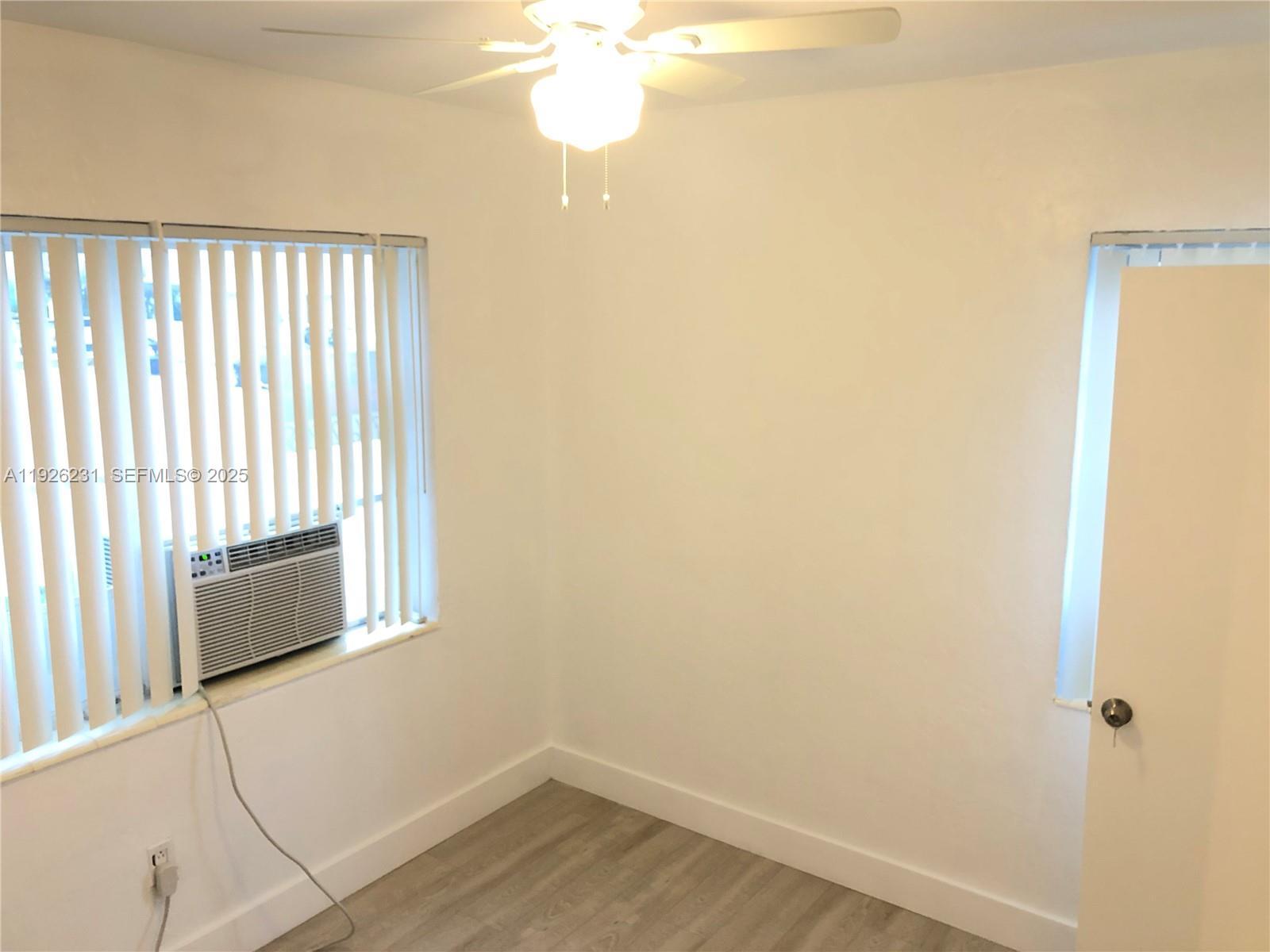 8340 Crespi Boulevard, Unit 19 Miami Beach, FL 33141 - Photo 16 of 35 a view of a livingroom with wooden floor and a window