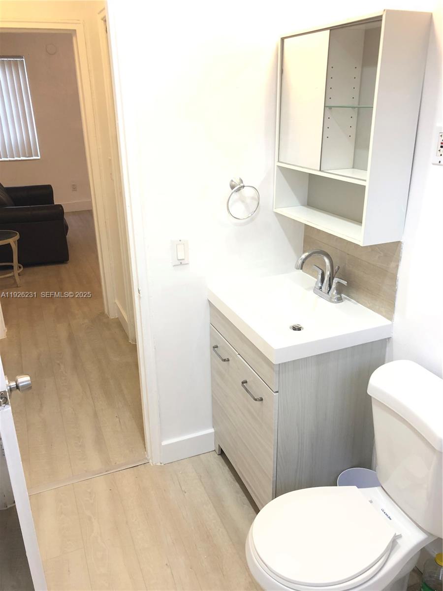 8340 Crespi Boulevard, Unit 19 Miami Beach, FL 33141 - Photo 22 of 35 a bathroom with a sink a toilet and mirror