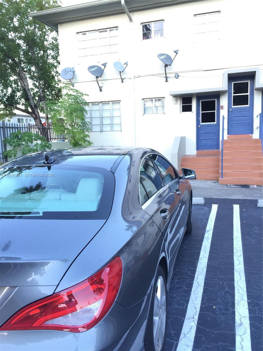 8340 Crespi Boulevard, Unit 19 Miami Beach, FL 33141 - Photo 28 of 35 a view of a patio with couches table and chairs with wooden floor