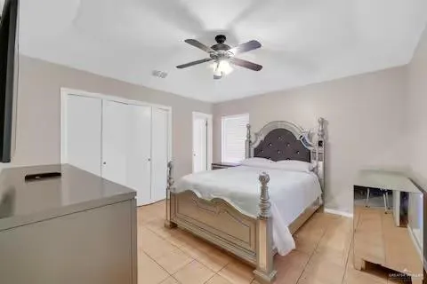 a bedroom with a bed and a ceiling fan