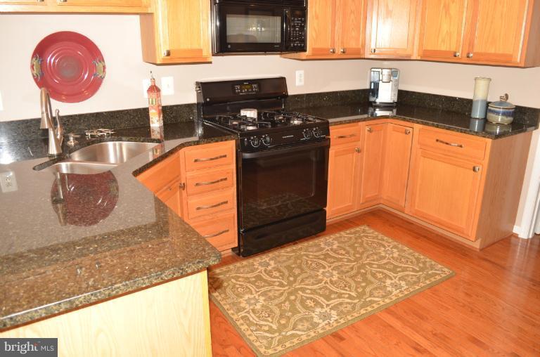 2407 Rippling Brook Road Frederick, MD 21701 - Photo 5 of 30 a kitchen with stainless steel appliances granite countertop a stove a sink and a microwave