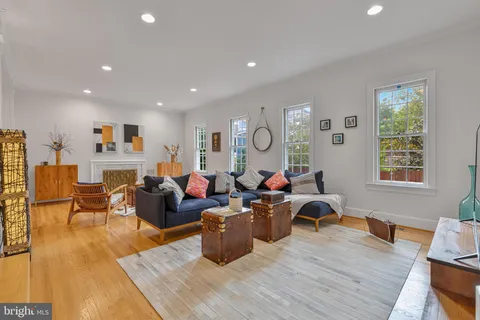 a living room with fireplace furniture and a large window