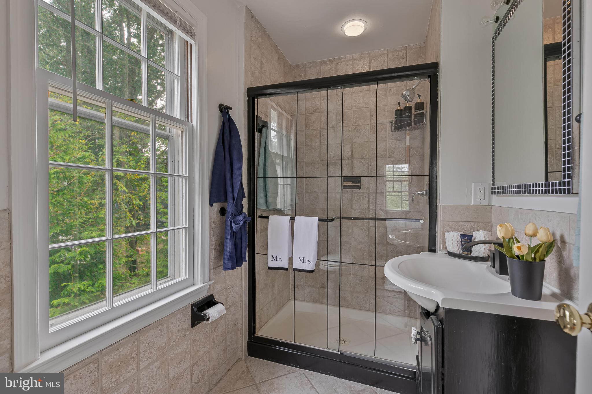 1340 North Lynnbrook Drive Arlington, VA 22201 - Photo 24 of 57 a bathroom with a granite countertop sink a mirror and shower