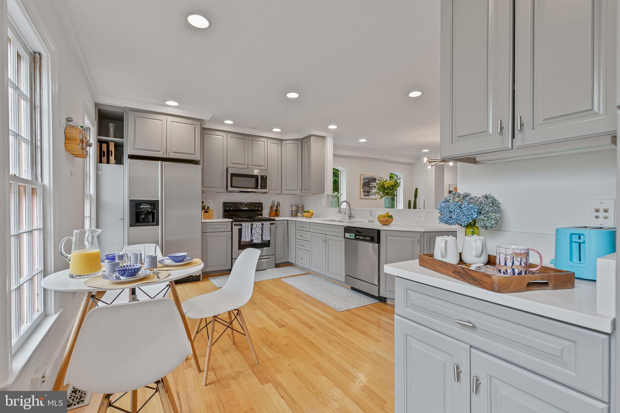 1340 North Lynnbrook Drive Arlington, VA 22201 - Photo 6 of 57 a open kitchen with stainless steel appliances kitchen island granite countertop a refrigerator a sink a stove and white cabinets with wooden floor