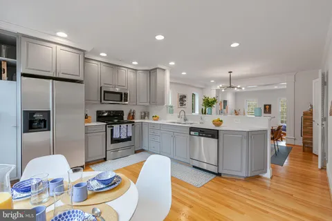 a kitchen with stainless steel appliances kitchen island granite countertop a refrigerator and a stove top oven