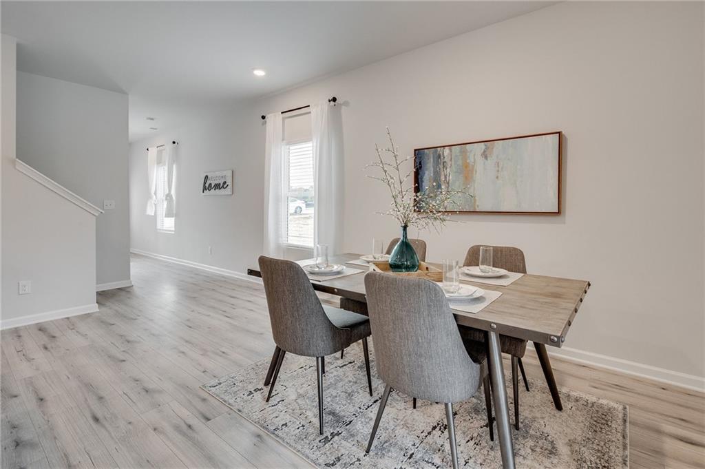 7437 Knoll Hollow Road Lithonia, GA 30058 - Photo 12 of 46 a view of a dining room with furniture and wooden floor