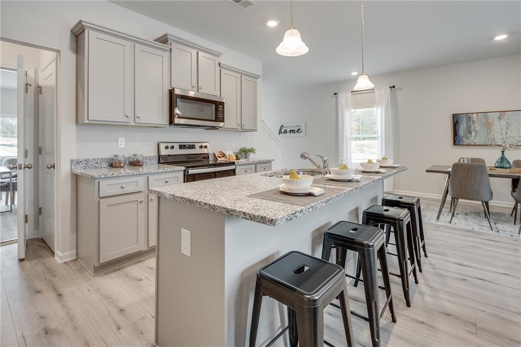 7437 Knoll Hollow Road Lithonia, GA 30058 - Photo 18 of 46 a kitchen with granite countertop white cabinets and stainless steel appliances