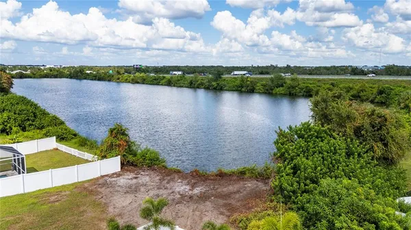 an aerial view of a house with swimming pool and lake view