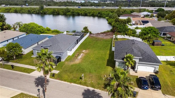 an aerial view of residential houses with outdoor space and lake view