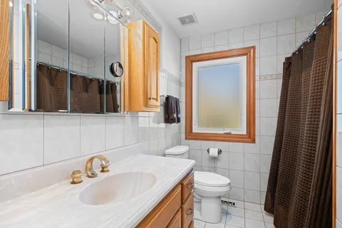 a bathroom with a sink a toilet and a mirror