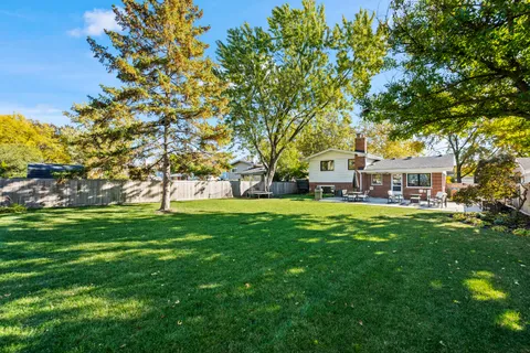 a view of house with garden space and trees