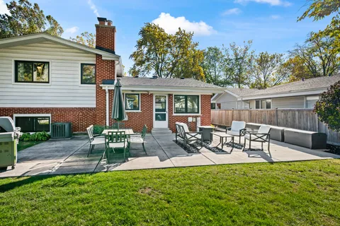 a view of a house with backyard sitting area and garden