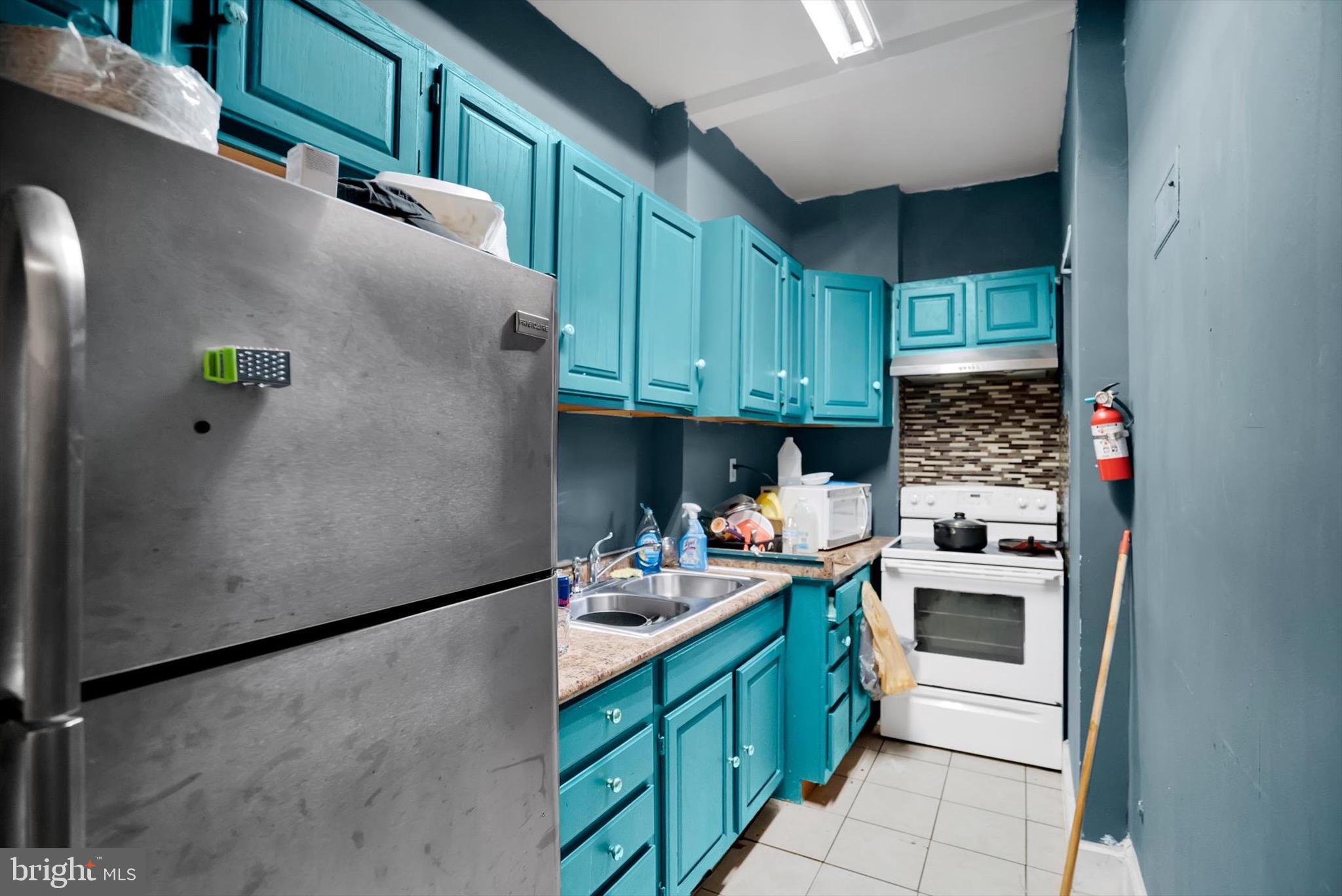 400 North 5th Street Reading, PA 19601 - Photo 20 of 25 a kitchen with stainless steel appliances granite countertop a refrigerator a stove and a sink with wooden cabinets
