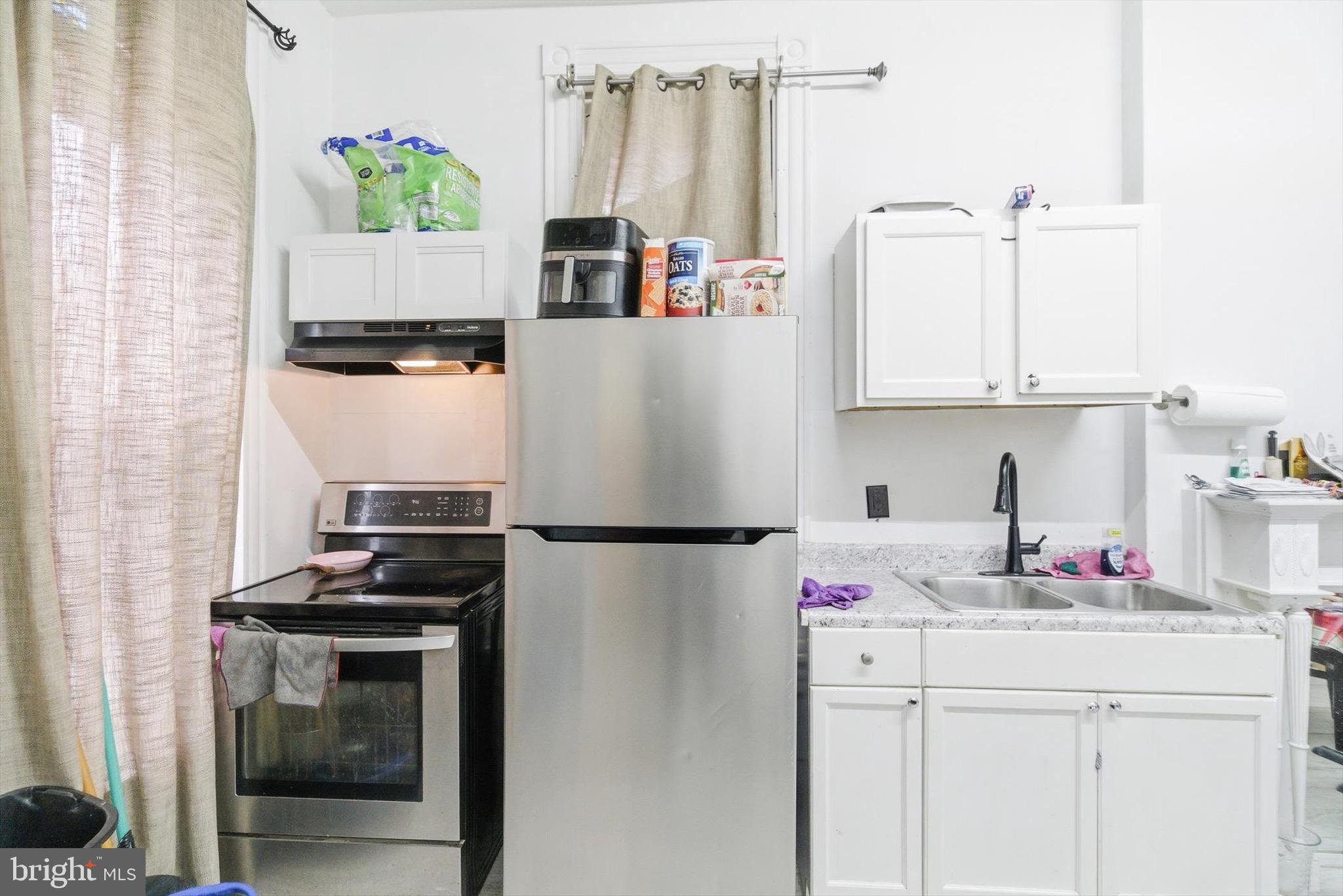 400 North 5th Street Reading, PA 19601 - Photo 4 of 25 a kitchen with refrigerator a stove a sink and a refrigerator