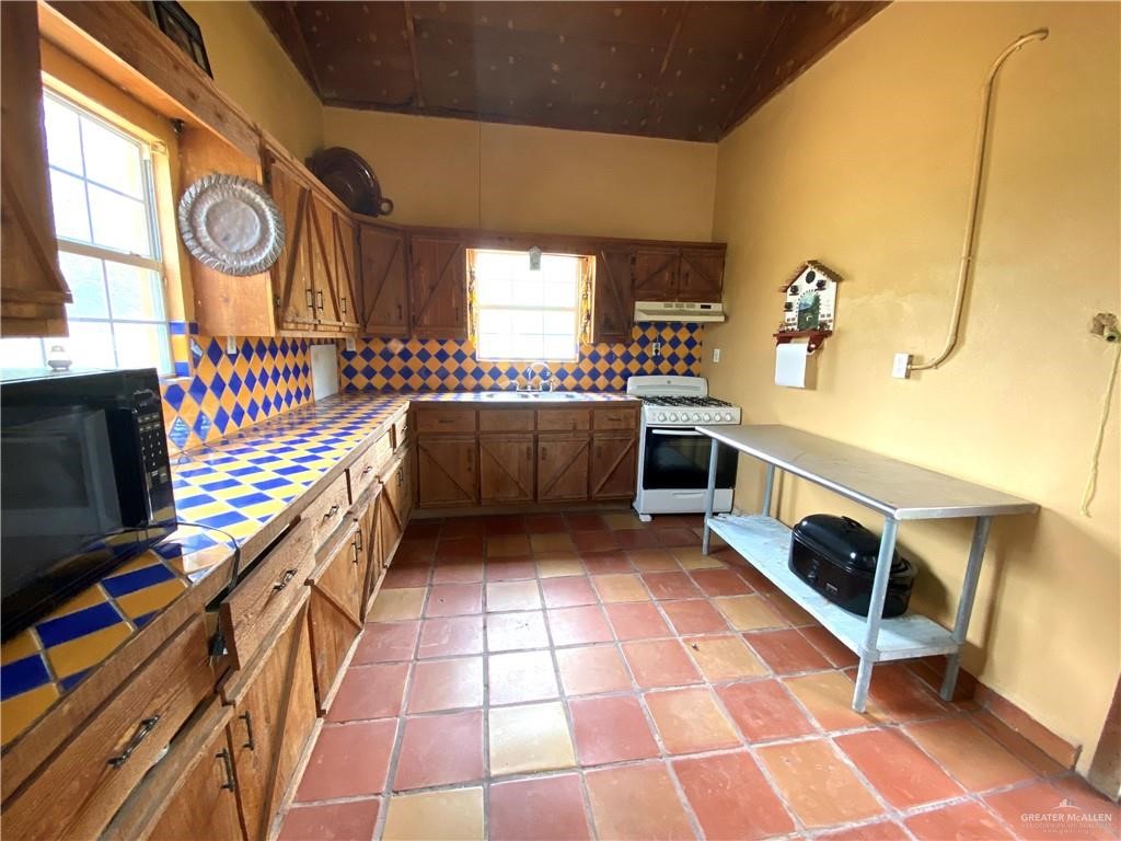 4113 Goodwin Road Mission, TX 78574 - Photo 9 of 14 a kitchen with stainless steel appliances granite countertop a stove a sink and a microwave