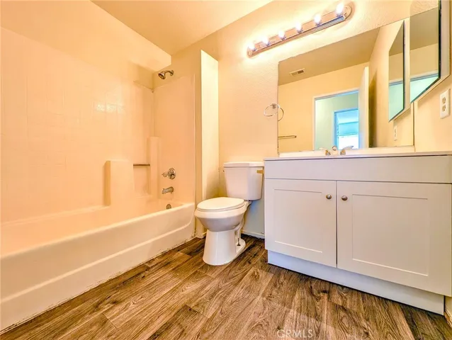 a bathroom with a granite countertop toilet sink and mirror