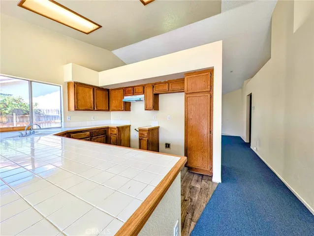 a view of a kitchen with wooden floor and a window