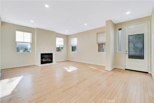 a view of empty room with wooden floor and fireplace