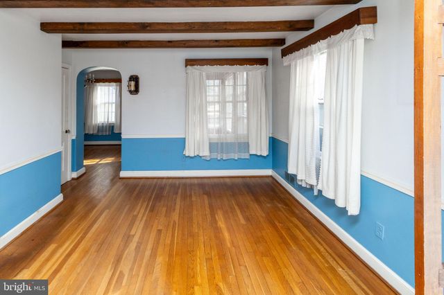 a view of empty room with window and wooden floor