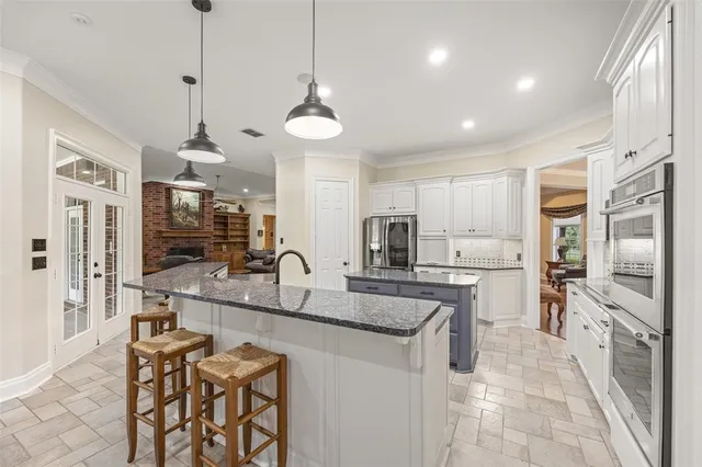 a kitchen with stainless steel appliances granite countertop a sink and a refrigerator