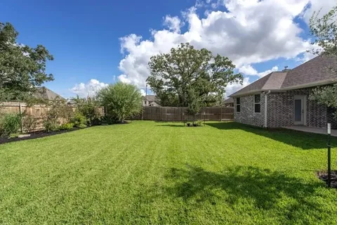 a view of a house with backyard and garden