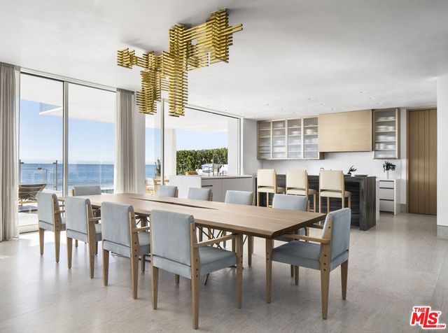 a kitchen with granite countertop furniture a stove a sink a dining table and chairs