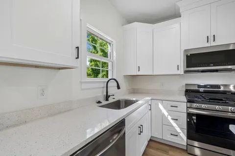 a kitchen with a refrigerator a sink a stove a microwave and island