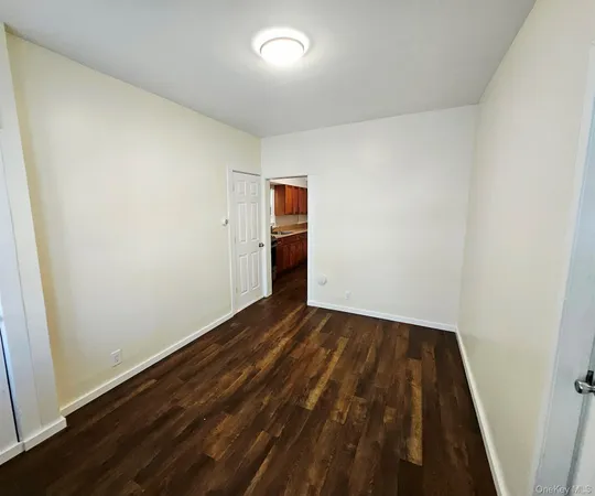 an empty room with wooden floor and closet