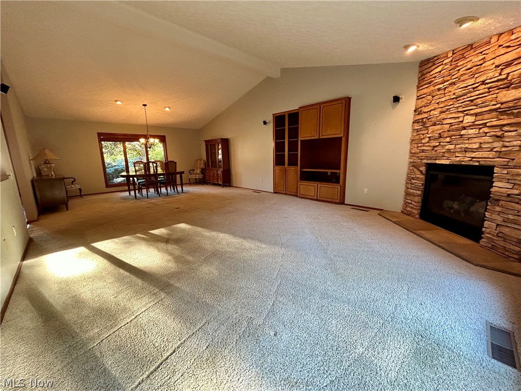 8763 Timber Edge Drive North Ridgeville, OH 44039 - Photo 13 of 40 Unfurnished living room with a chandelier, a fireplace, carpet floors, and vaulted ceiling